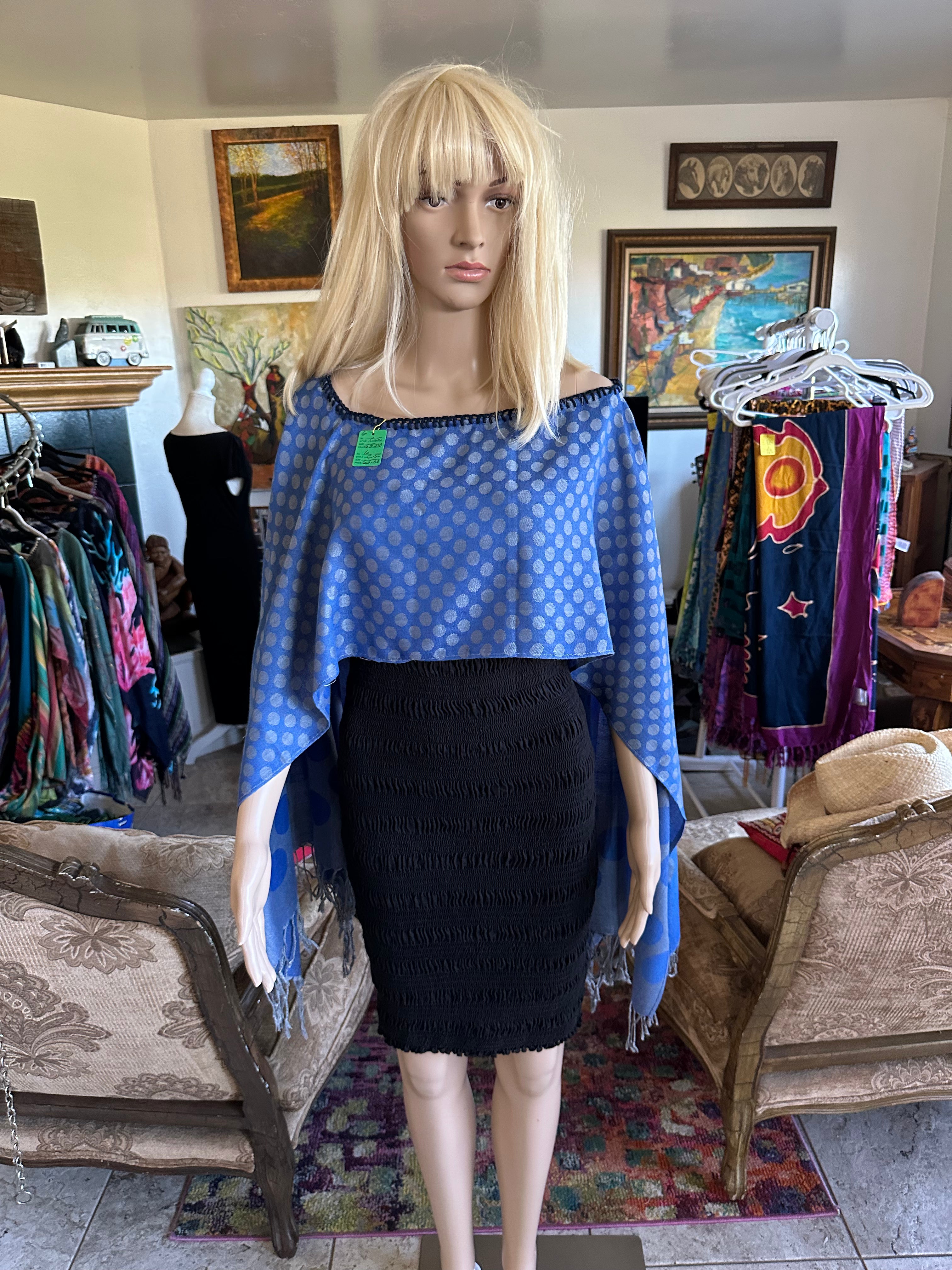 Mannequin wearing a blue patterned top and black skirt in a store setting.
